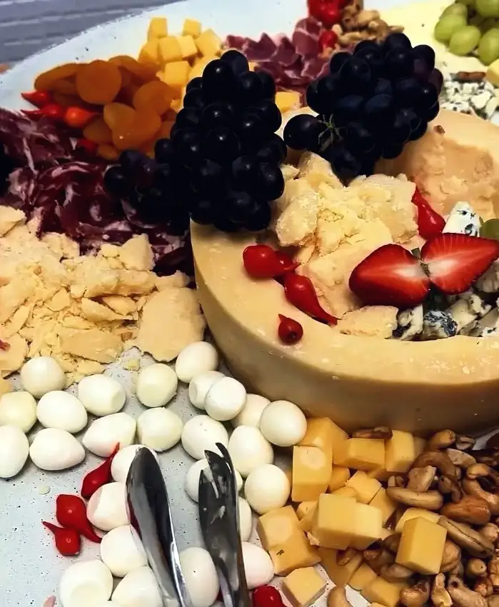 Tábua da casa com queijos, frios, uvas, morangos, muçarela de búfala e castanhas