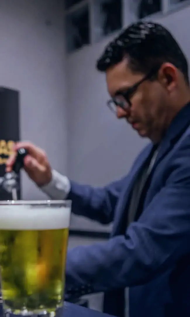 Chopp tirado no balcão por quem atende de terno