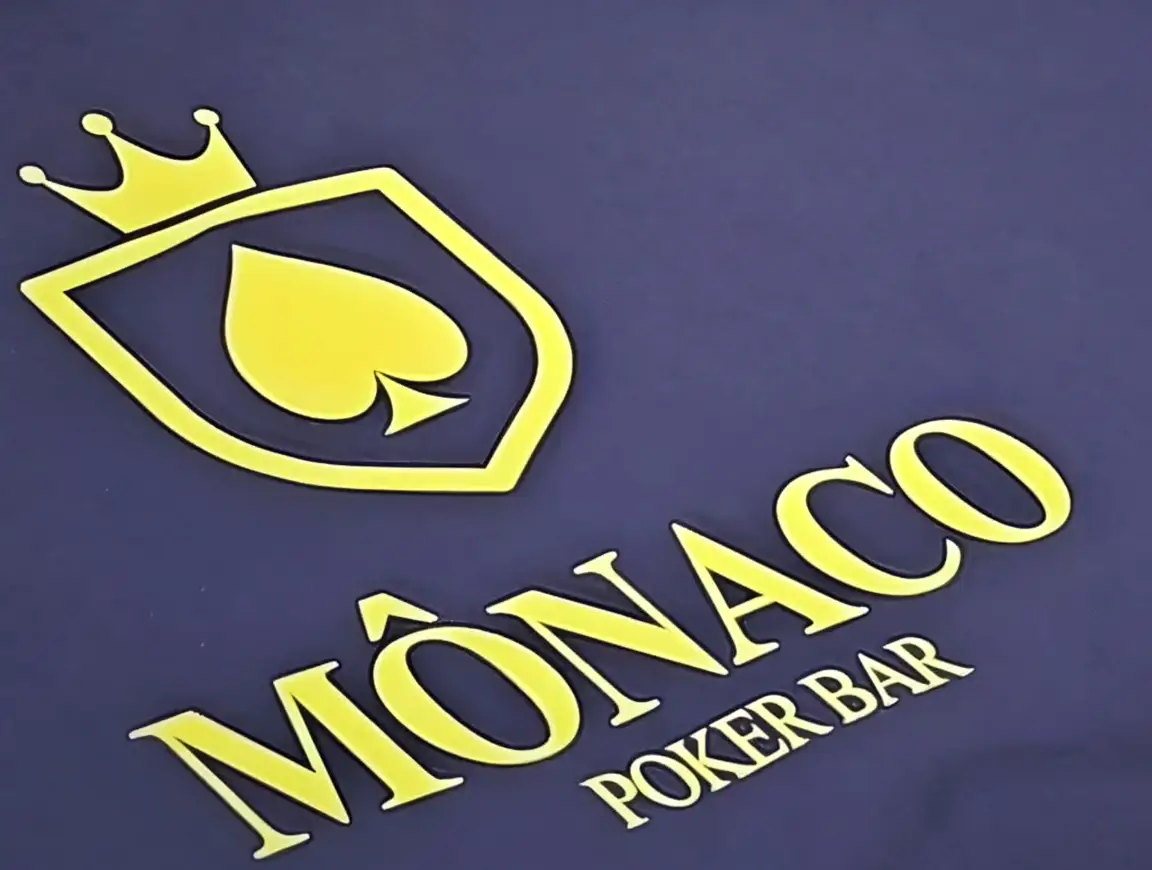 O feltro índigo de uma mesa do Monaco, com o escudo e o nome da casa em amarelo